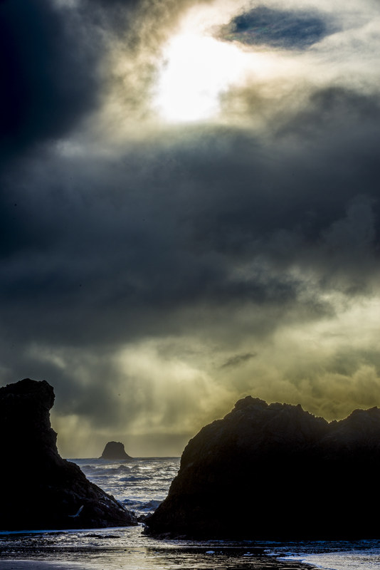 Ruby Beach sea stacks silhouetted in dramatic storm light with waves and sea spray